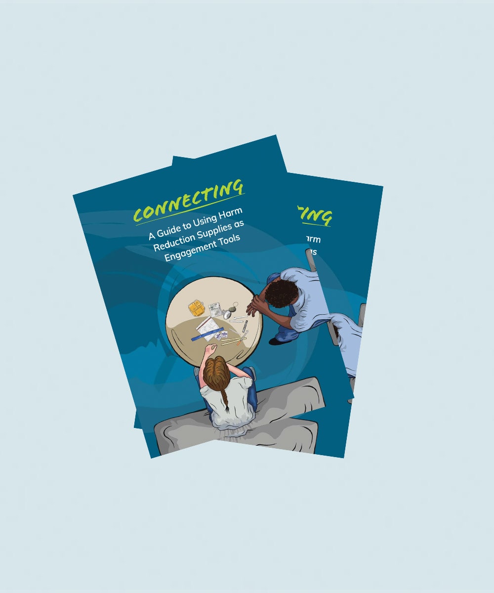 Cover of the Connecting Manual featuring two people sitting around a circular table with harm reduction supplies on it